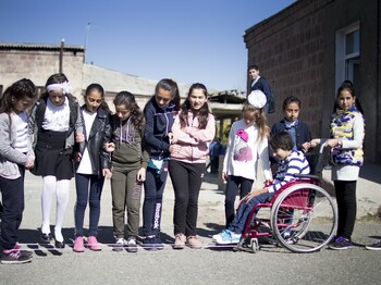 Eine Schulklasse steht auf dem Pausenhof zu einem gruppenfoto zusammen.