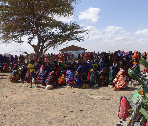 Eine große Gruppe von Menschen in Kenia wartet auf eine Lebensmittelverteilung.